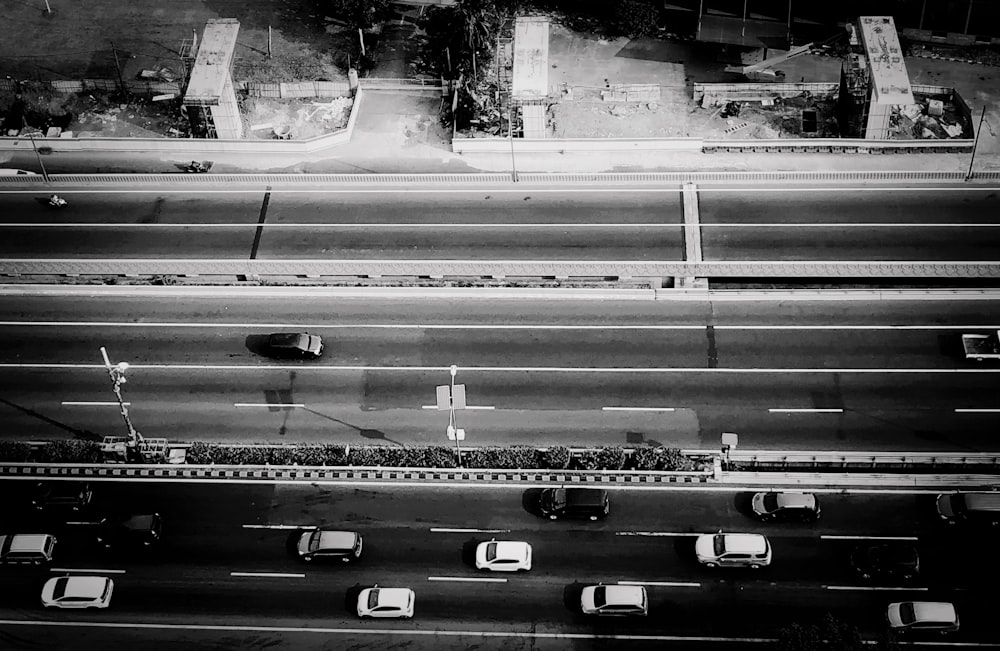 grayscale photography of vehicles on road