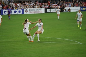 A football player celebrating a goal with teammates in a crowded stadium