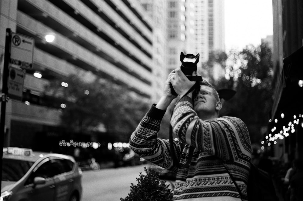 grayscale photography of man taking photo