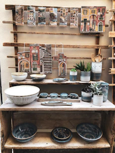 Decorative ceramic pieces arranged on a rustic wooden shelf.
