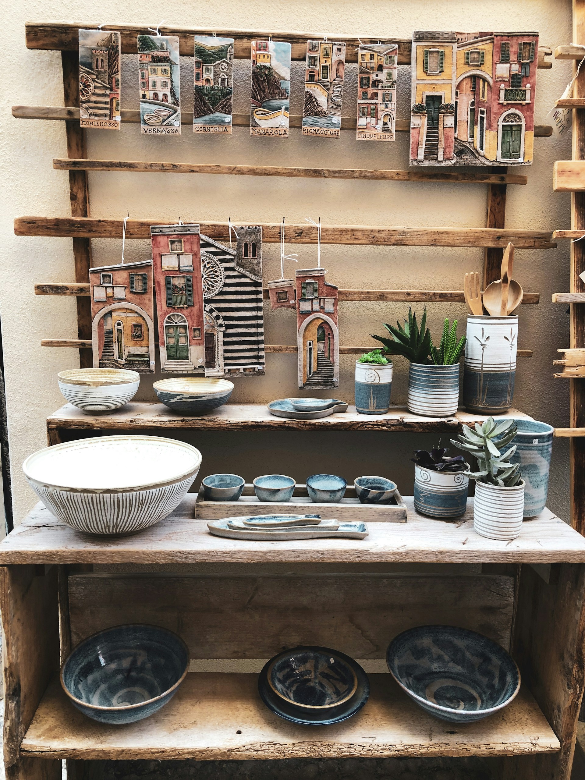 Traditional Spanish ceramic pottery arranged on a rustic shelf.