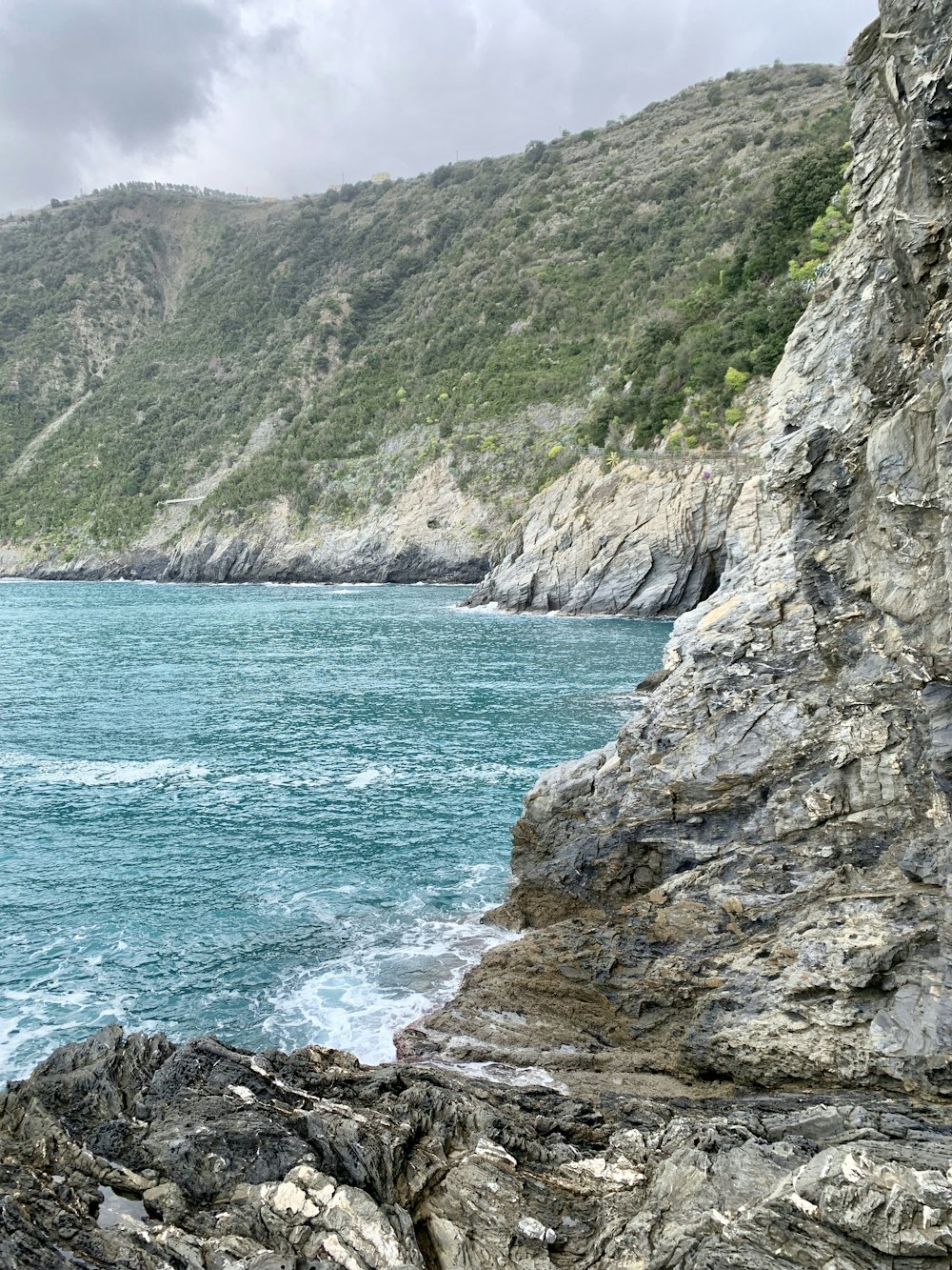 body of water besides green and gray hills