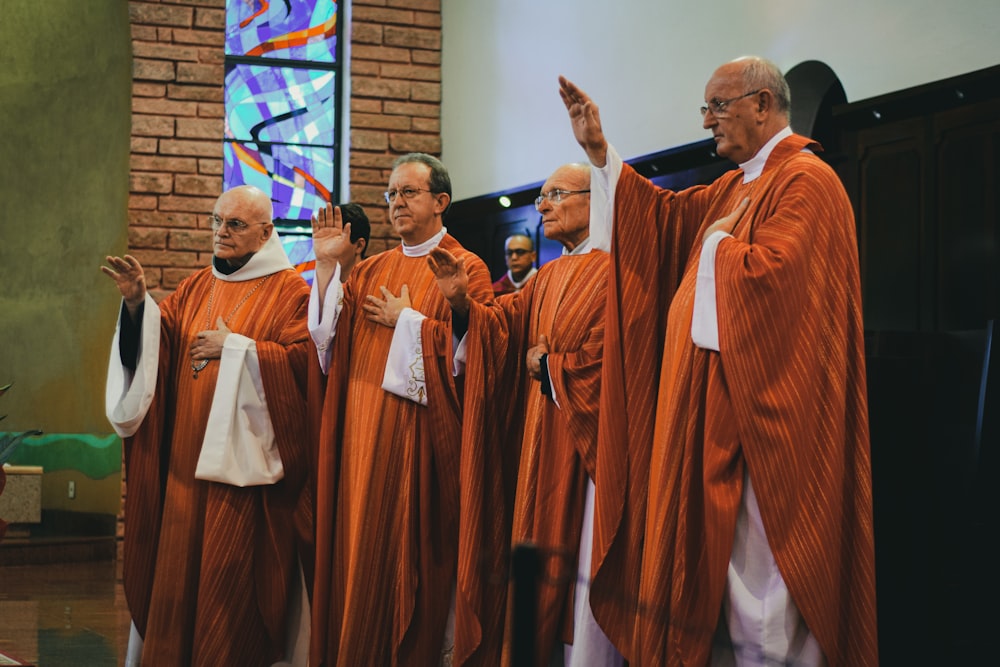 교회 안에서 기도하는 네 명의 사제