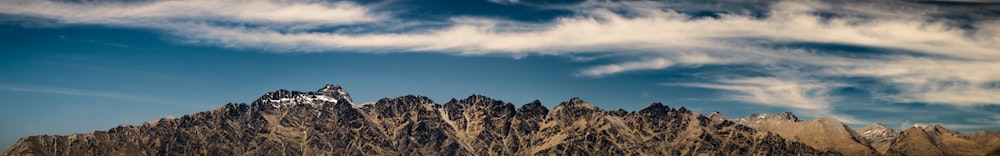 aerial photo of mountains under cloudy sky