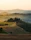 Scenic Tuscan farm with rolling hills at sunset.