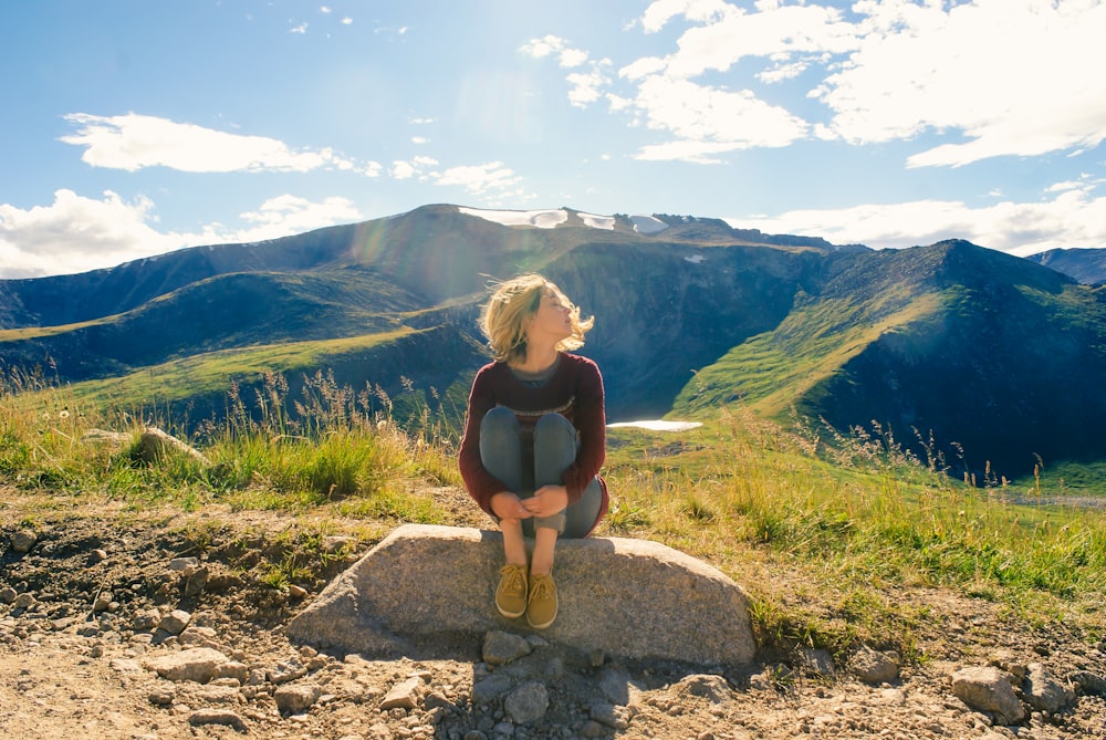 woman sitting on rock