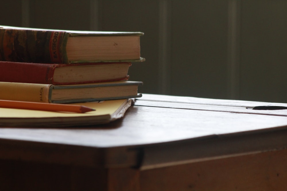 books and pencil on wooden table