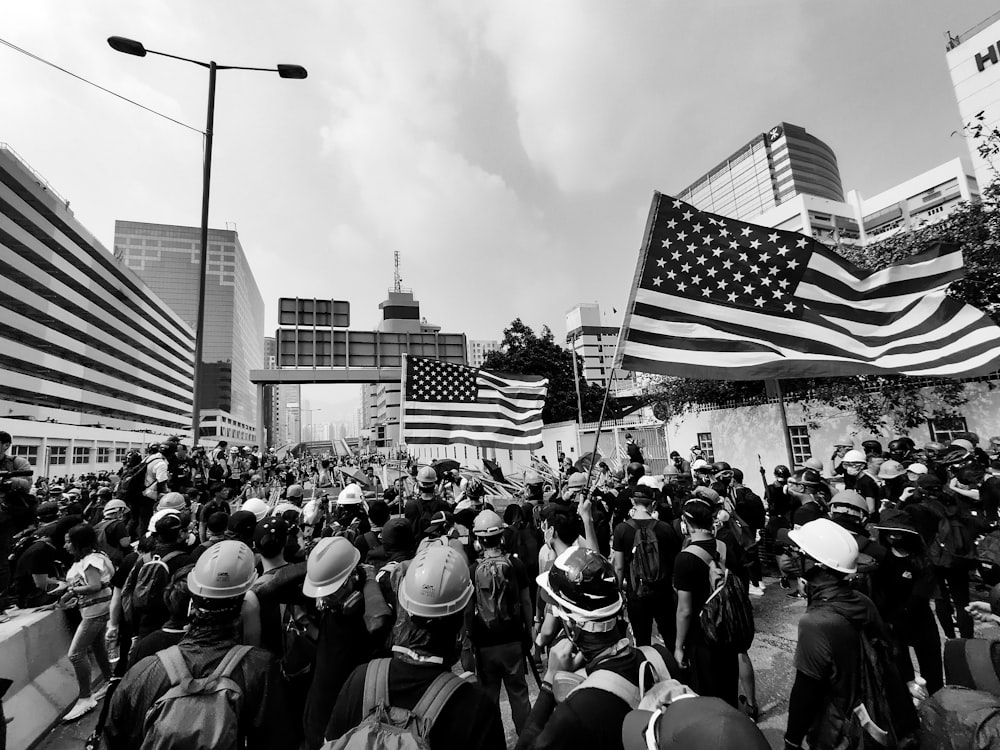 grayscale photo of people holding U.S. flag