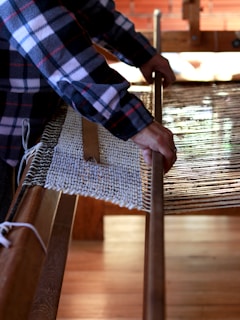 person weaving cloth
