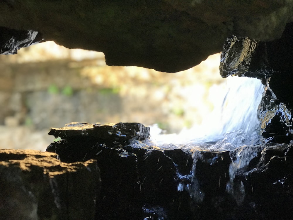 a small waterfall coming out of a cave