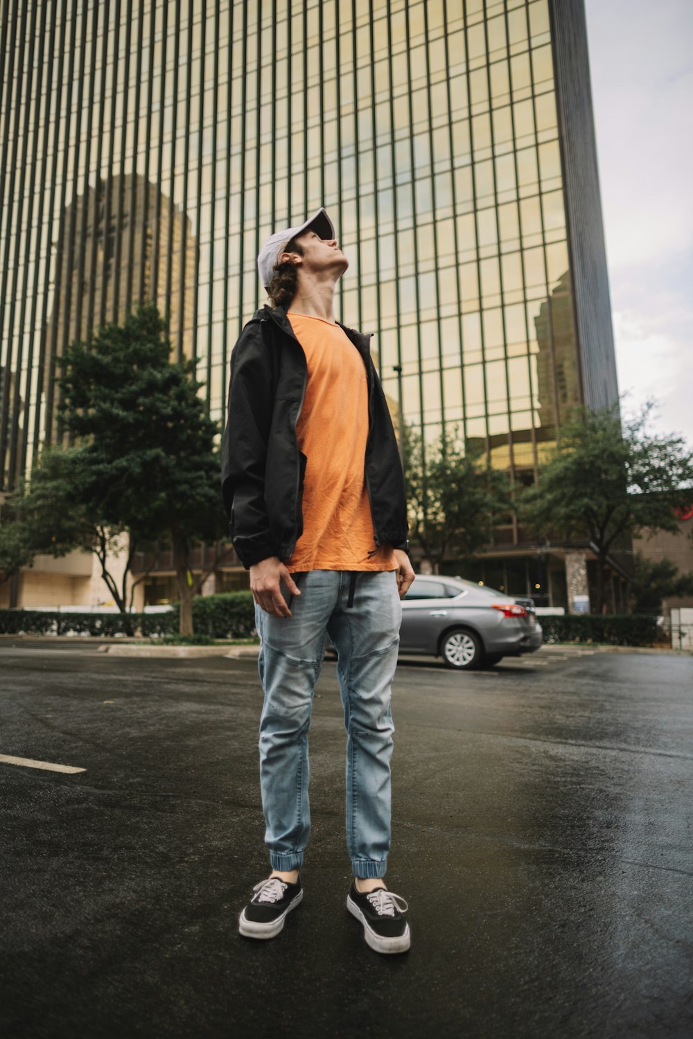 man standing near building and vehicle