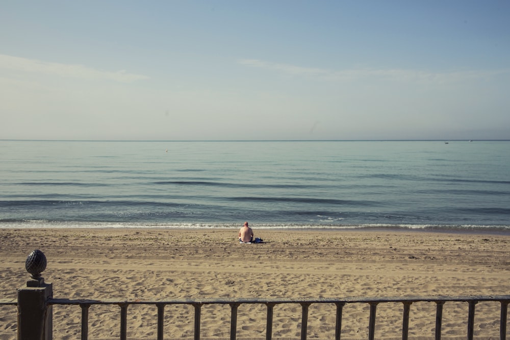 person sitting on shore