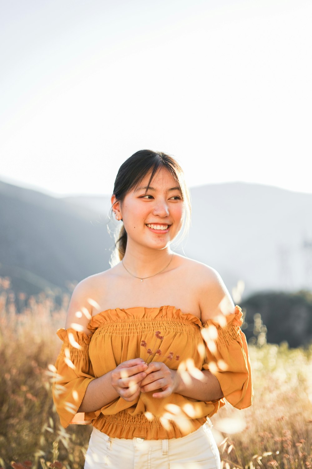 smiling woman wearing yellow off-shoulder top