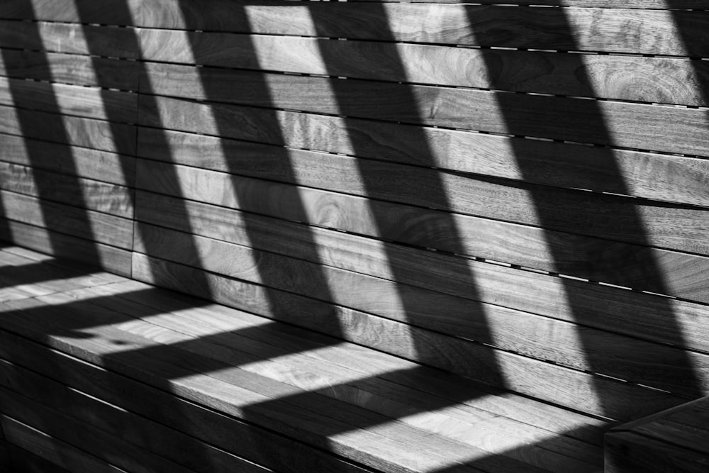 a wooden bench sitting next to a wooden wall