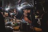A lively food festival scene with people enjoying various street food dishes.