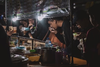 A diverse group enjoying international dishes at food stalls.