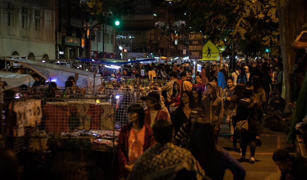 a crowd of people walking down a street at night