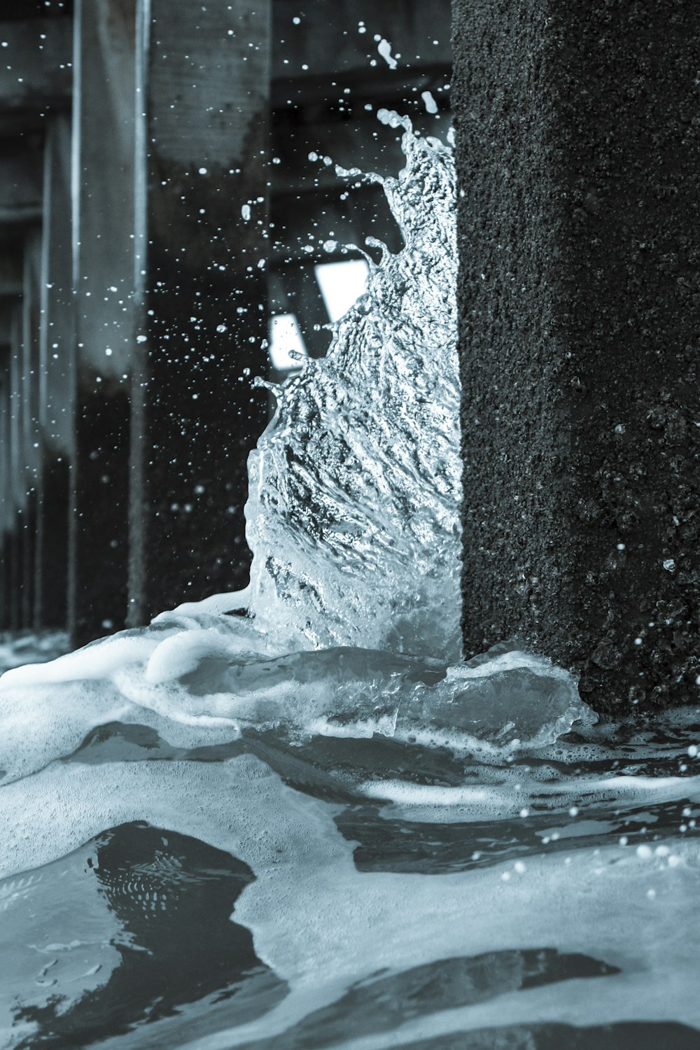 a black and white photo of water coming out of a pipe