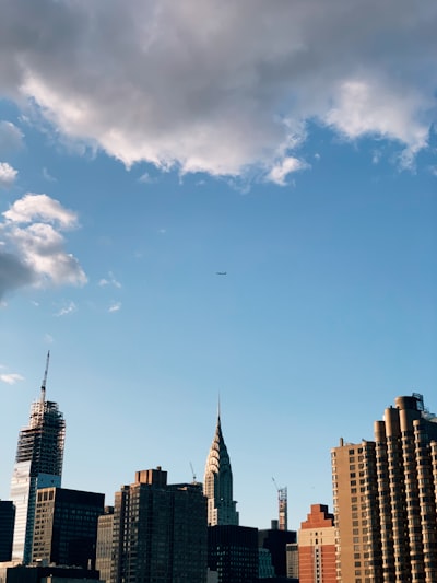 gray and brown buildings under blue skye and gray clouds