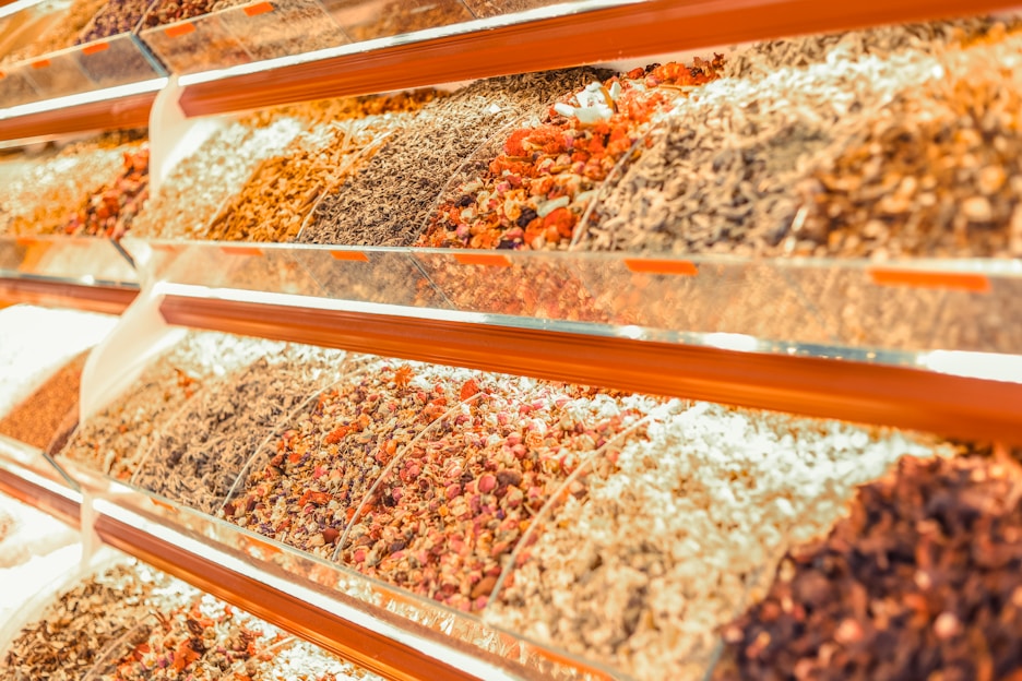A vibrant assortment of spices in glass jars arranged on a wooden table.