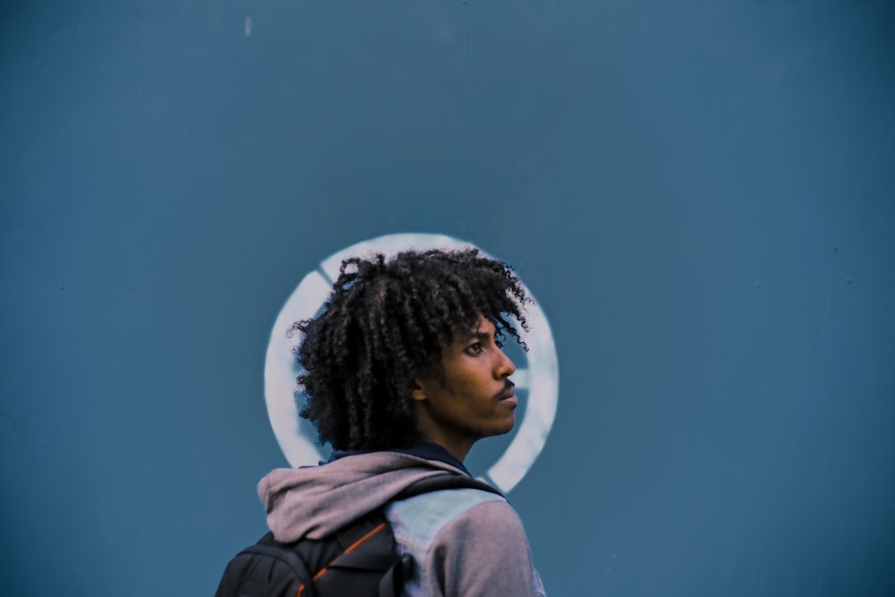 man wearing gray hoodie and black backpack