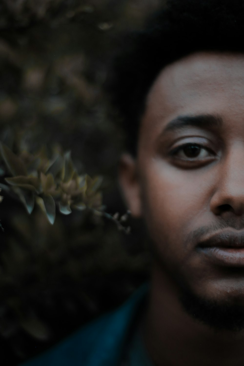 a close up of a person with a flower in the background