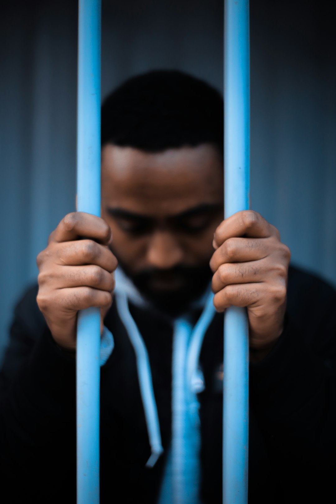 man in hoodie holding metal bars