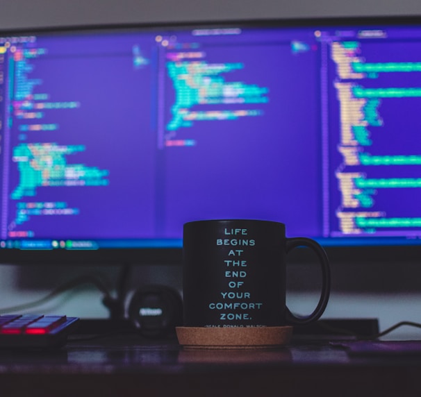 flat screen monitor and black ceramic mug