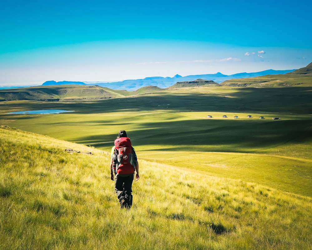 uomo che cammina sul campo di erba verde