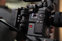 Close-up of hands adjusting professional video camera settings.