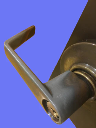 Close-up of a modern silver aluminium door handle against a white frame.