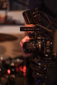 Close-up of hands adjusting camera and microphone settings in a studio.