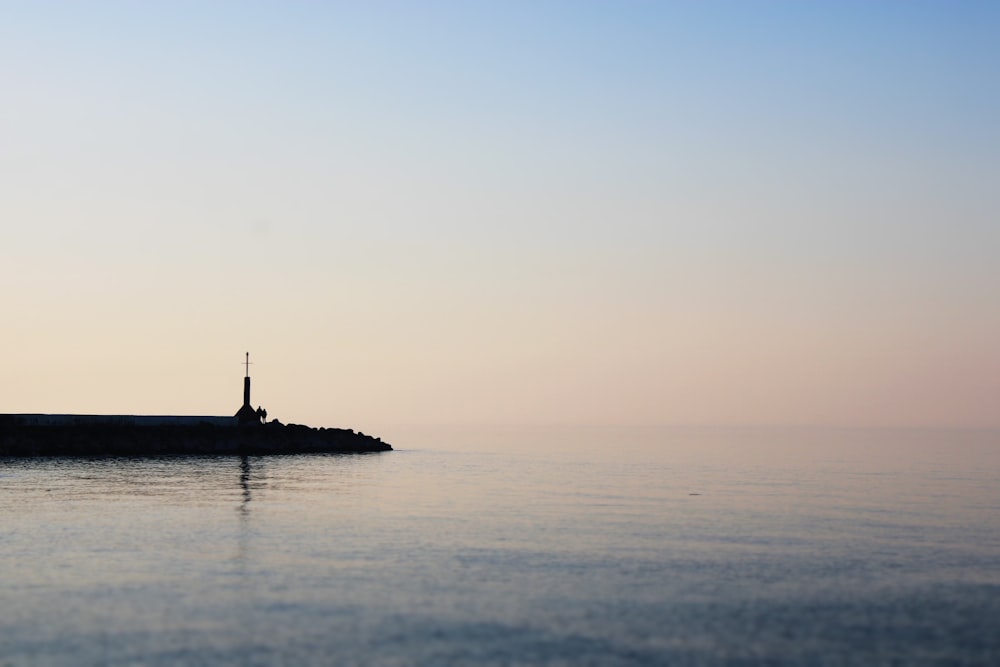 silhouette of lighthouse under clear sky