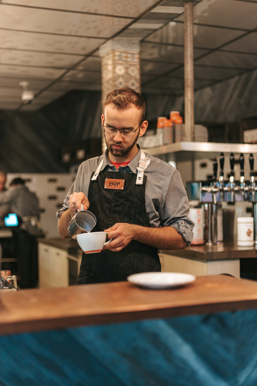 man pouring beverage in mug