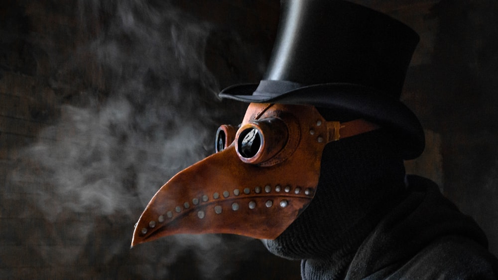 Un uomo che indossa una maschera di peste e un cappello a cilindro