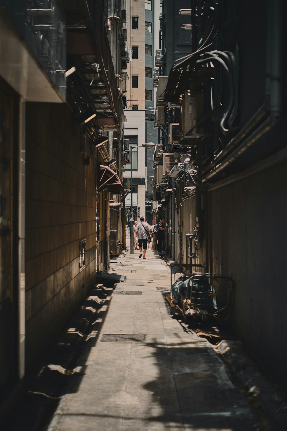 alley photography of person walkway between building during daytime