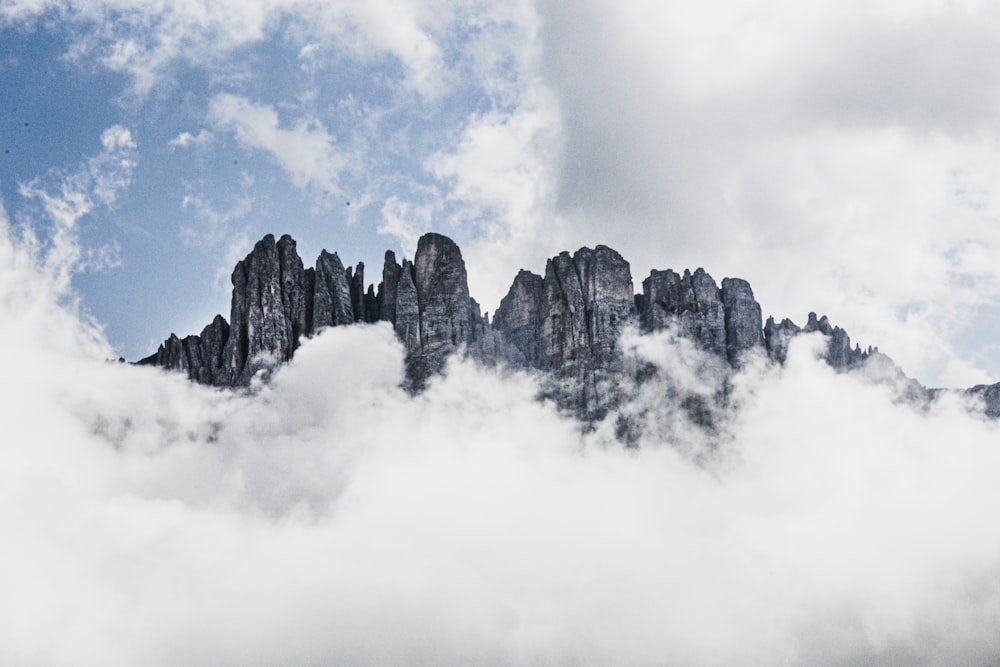 a mountain covered in clouds under a blue sky