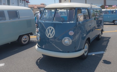 A lively outdoor meetup with classic Volkswagen Transporter T1 vans parked under blue skies.