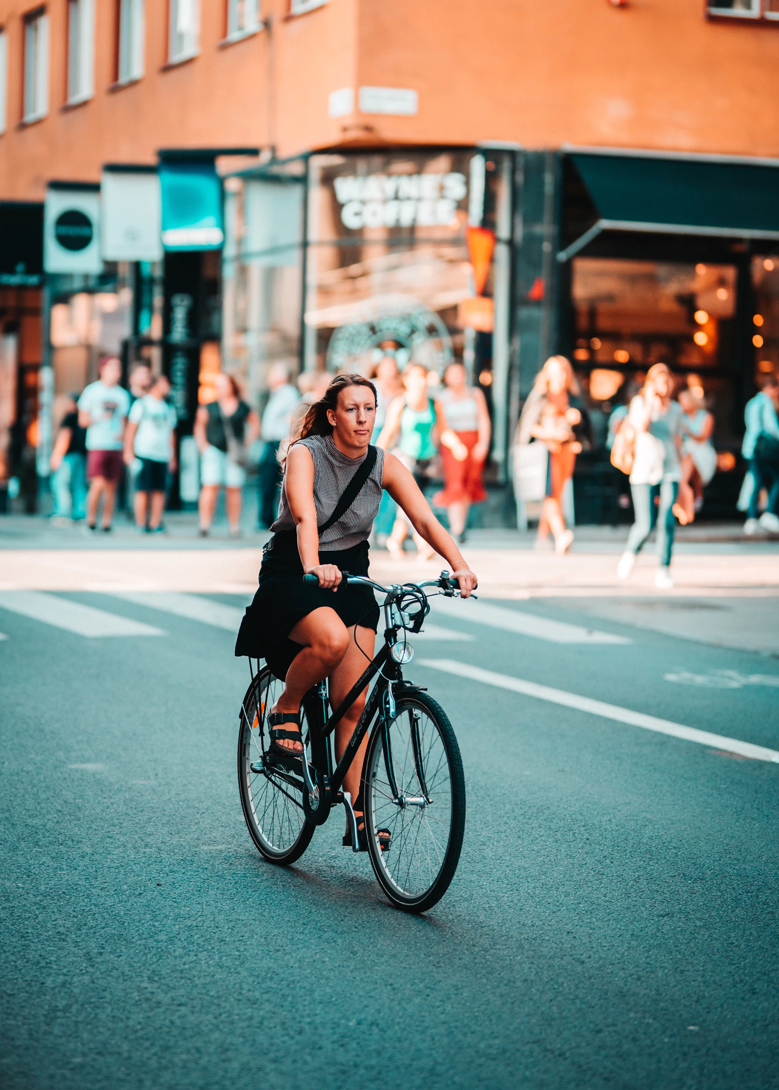 Urban cyclist riding a bicycle through a busy city street