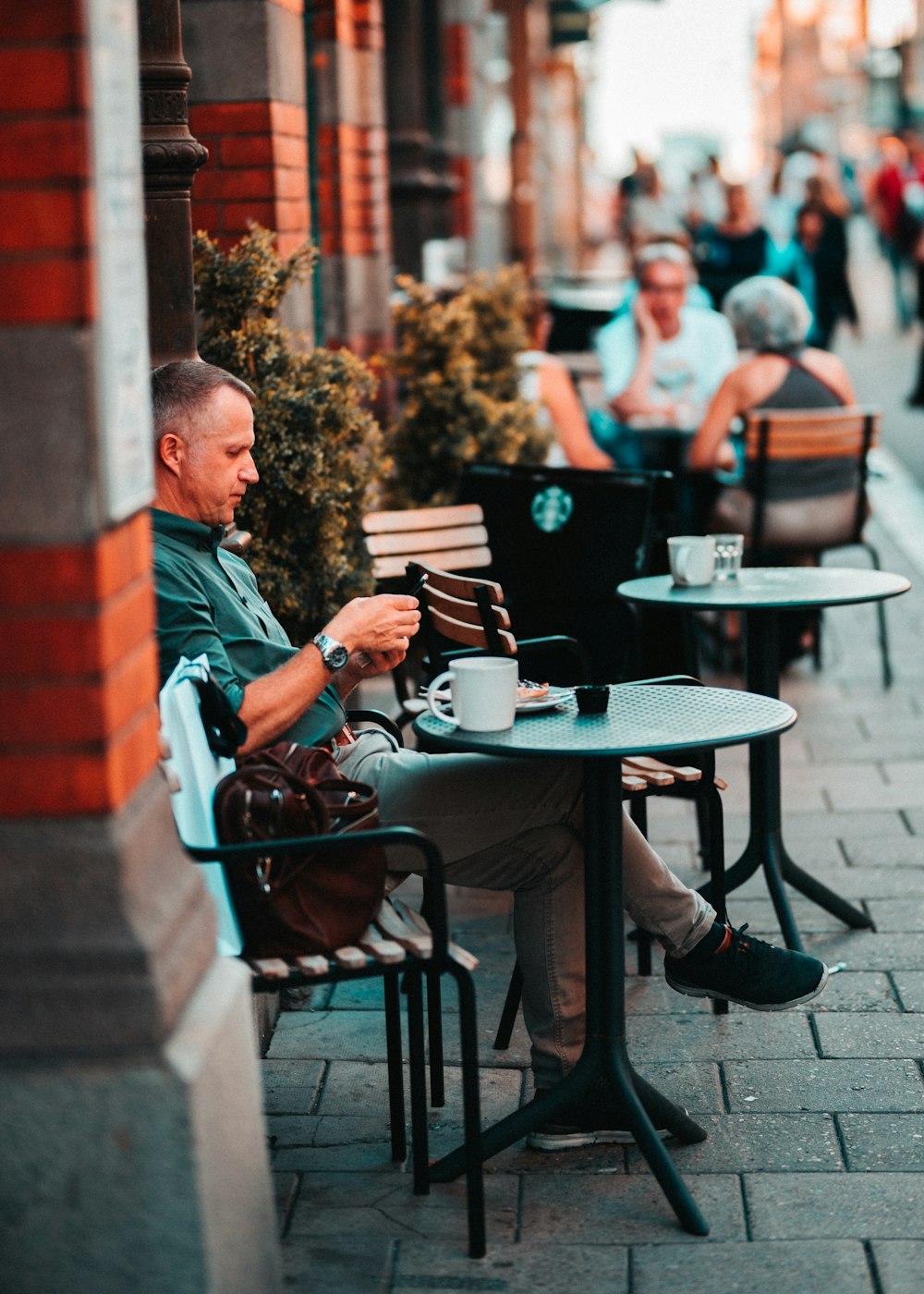man sitting on chair drinking coffee