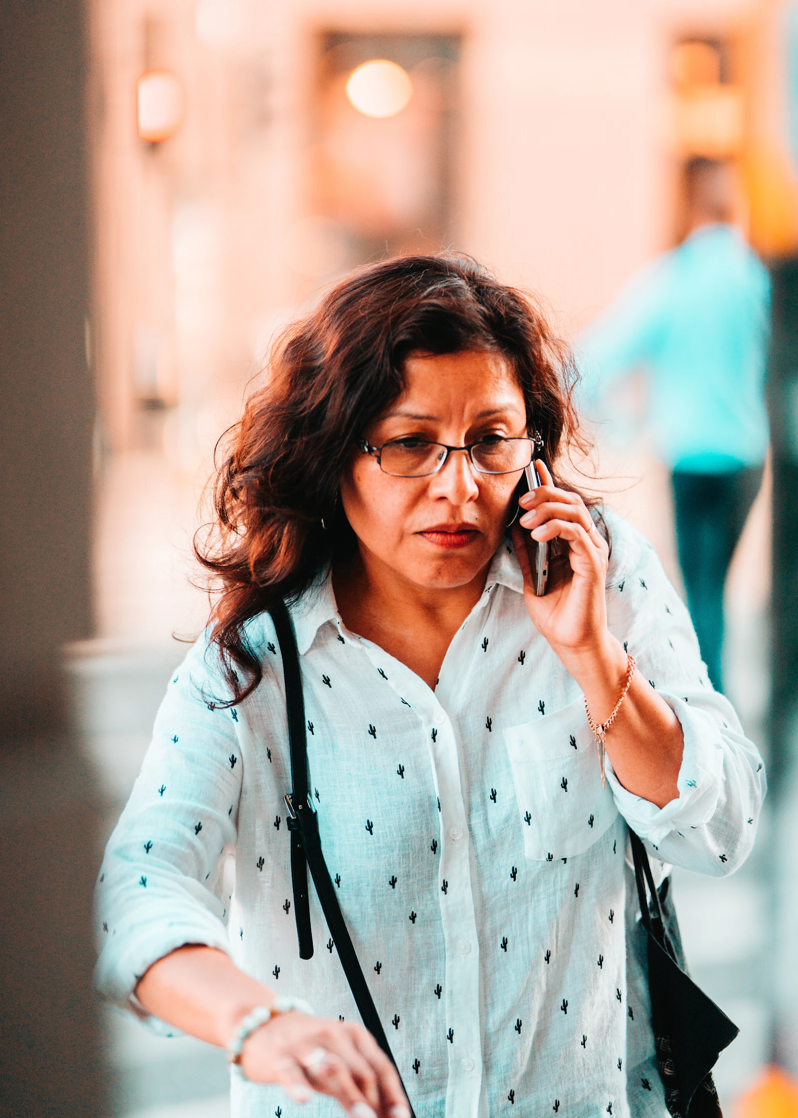 Woman on the phone outdoors, expression tense and searching, waiting to hear something real