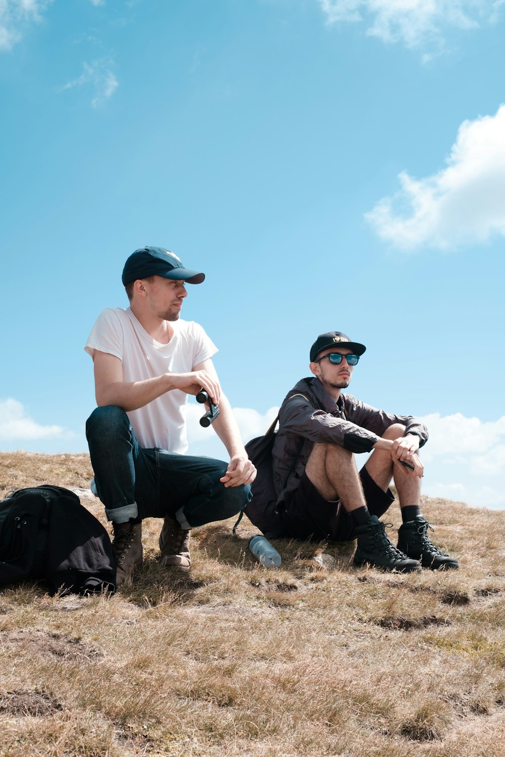 two men sitting on hills