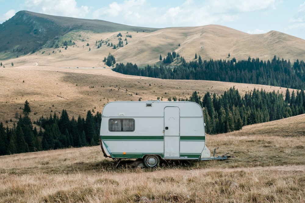 white and green RV at a brown lawn