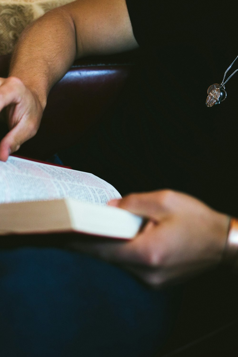 person sitting on sofa reading book