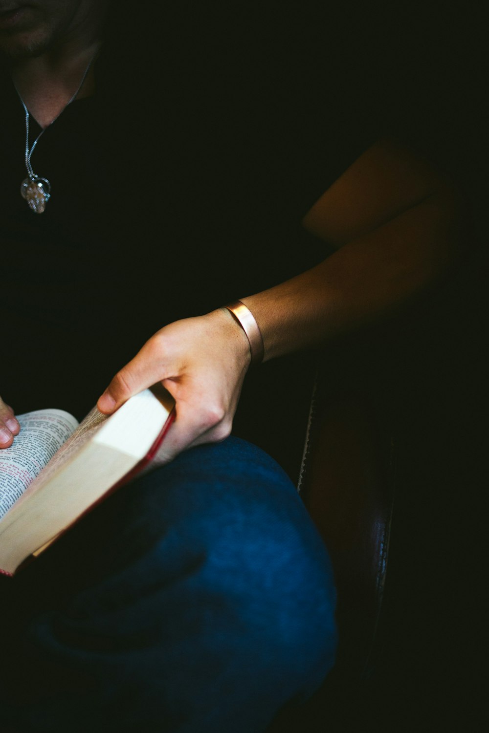 a person reading a book in a dark room