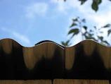 A wide shot showing a completed metal roof reflecting the blue sky.