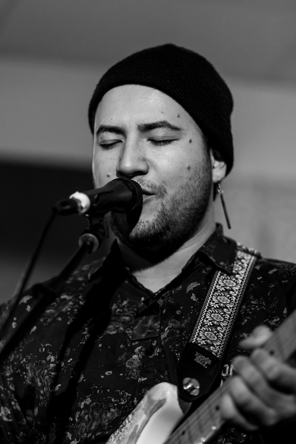 grayscale photo of man playing guitar