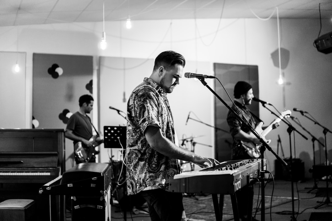 grayscale photo of man playing keyboard