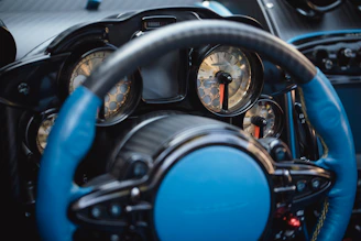 Close-up of a sleek black dashboard with illuminated chrome dials and gold accent lines.