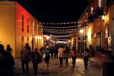 A lively street scene in Toulouse at night with people casually mingling.
